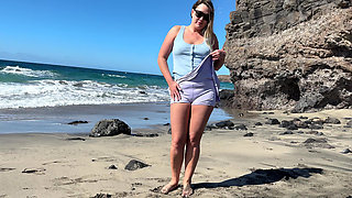 Girl pees in skirt shorts on the public beach